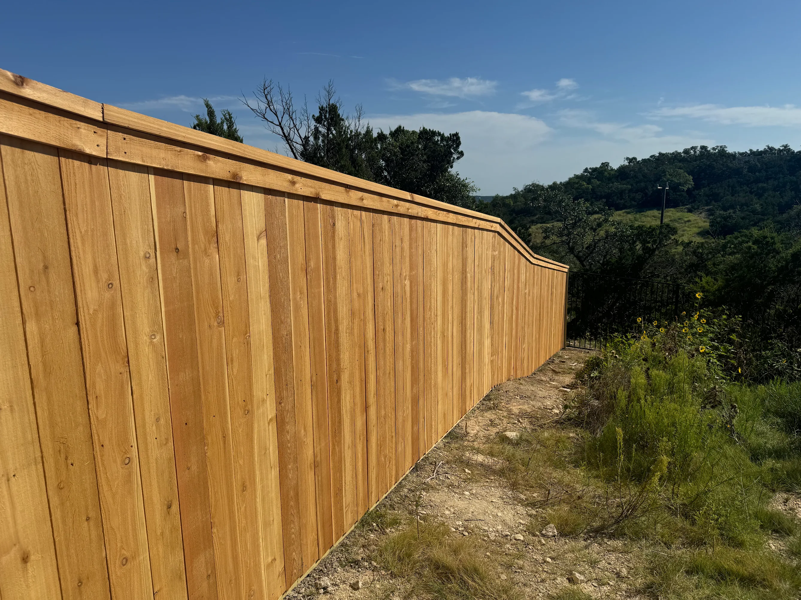 Custom wood fence installation on hillside