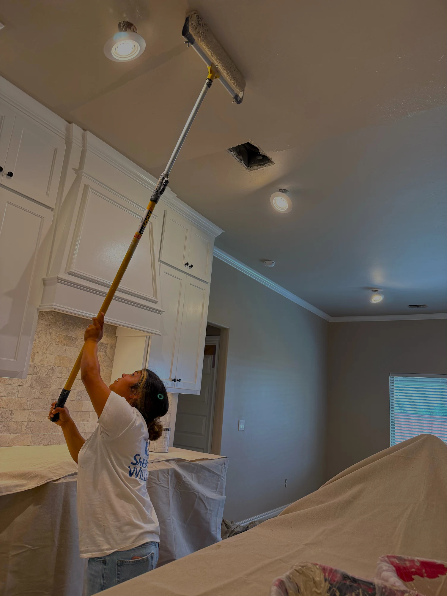 Professional painter applying ceiling paint